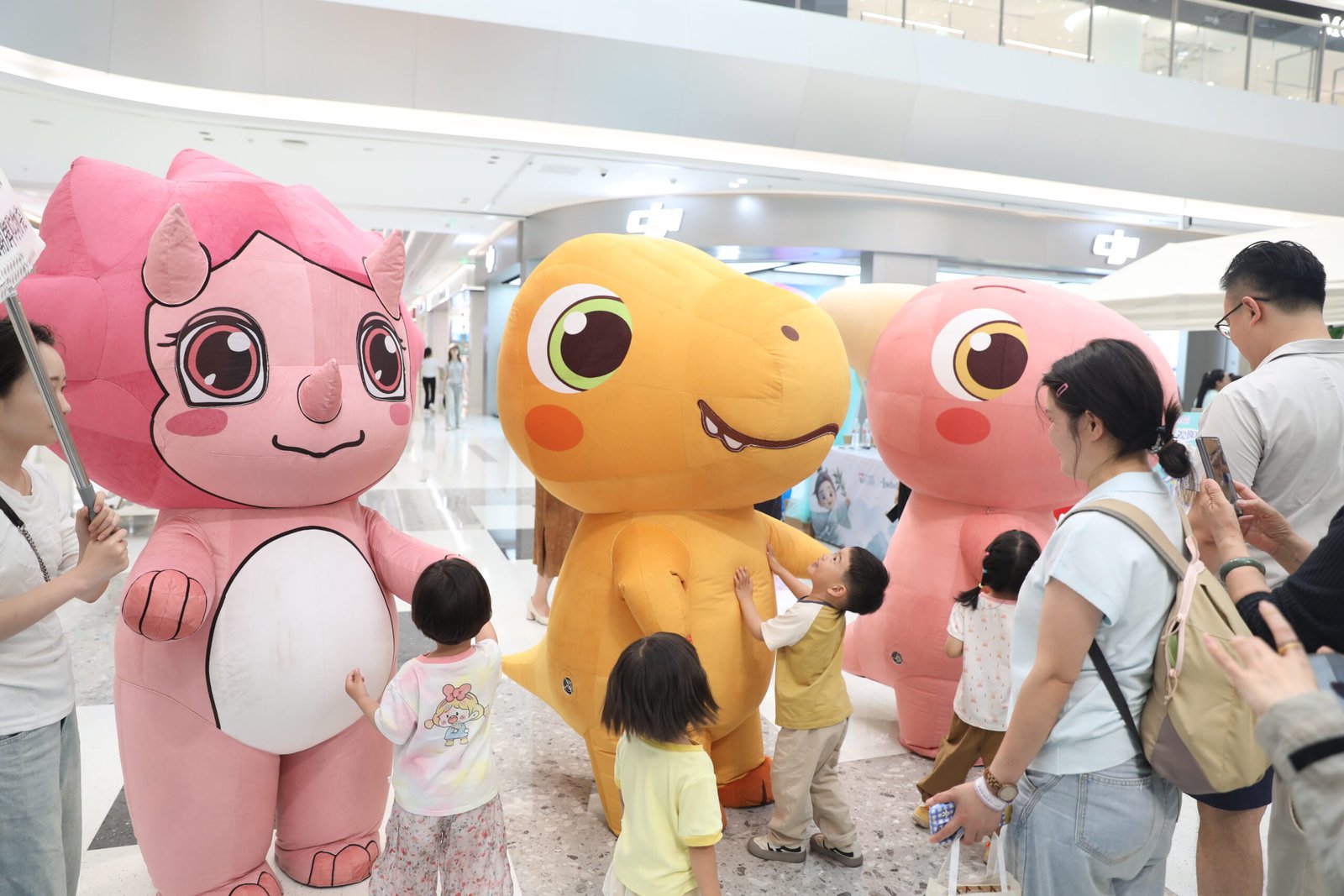 Three Little Dinosaurs character mascots meeting children at an event