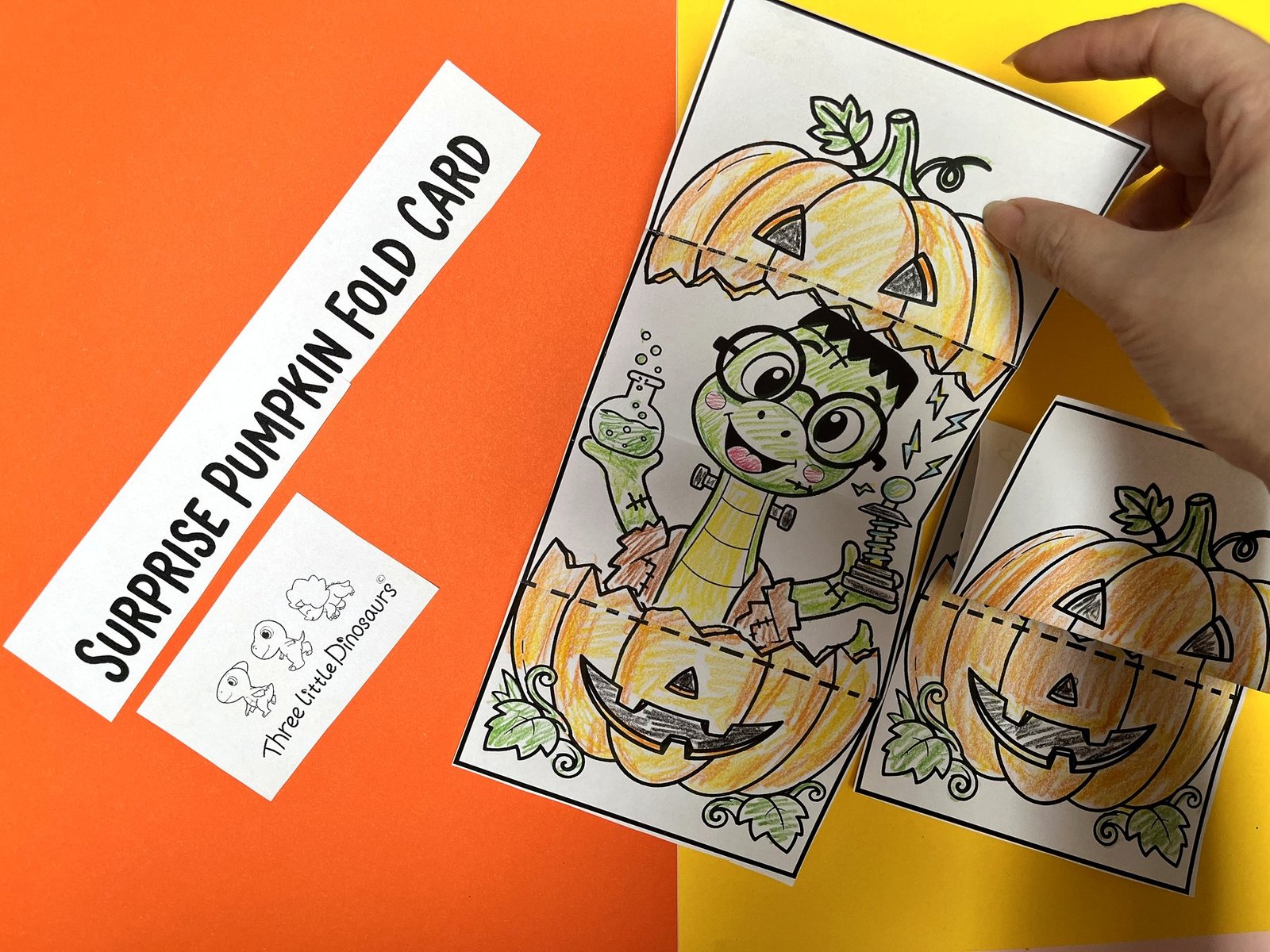 Hand folding the printable pumpkin card along the dashed line